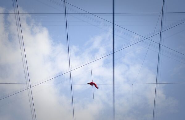 2ヶ月間の綱渡りの最終日にロープ上で横になるアディリ・ウクソールさん　北京 - Sputnik 日本