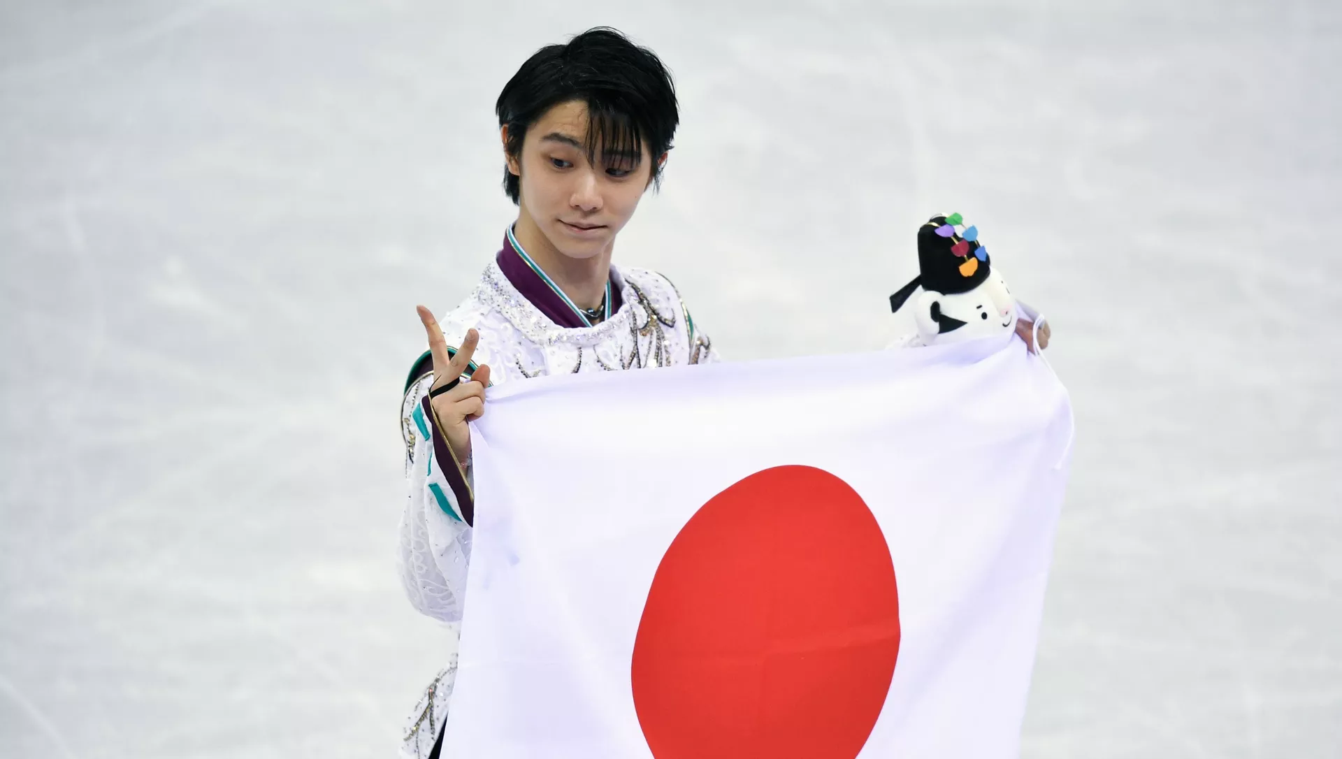日本の旗を持っている羽生選手
