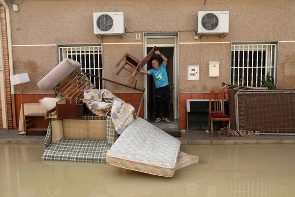 大雨による浸水でだめになった家具を投げ出す男性　スペイン - Sputnik 日本