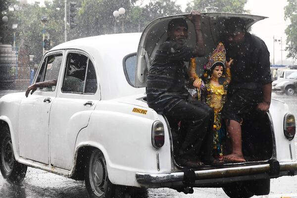 車のトランクでヴィシュヴァカルマンの彫像を運ぶ男性　インド　コルカタ - Sputnik 日本