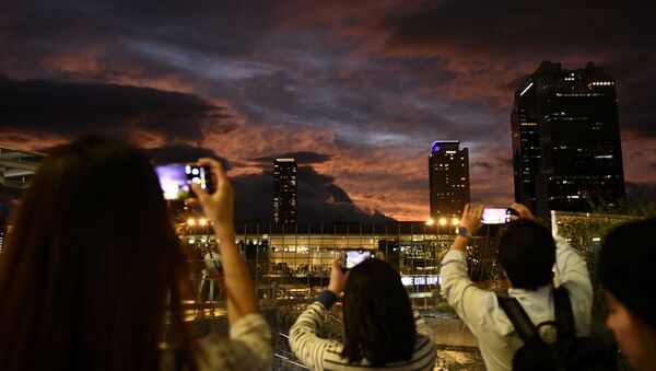 Люди фотографируют закатное небо во время приближения тайфуна «Хагибис» к Осаке, Япония - Sputnik 日本