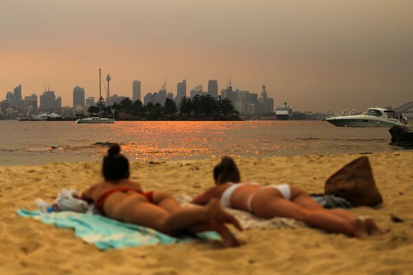 森林火災の煙を背にビーチで日焼けをする女性たち、オーストラリア - Sputnik 日本