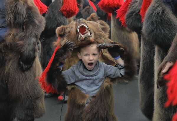 ルーマニアの町コマネシュティにて　新年のパレードでクマの着ぐるみを着る少年　歌って踊りながら町を練り歩き、悪を追い払う - Sputnik 日本