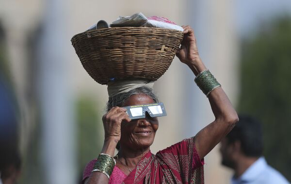 露天商の女性も日食観察用メガネで観察　インド - Sputnik 日本