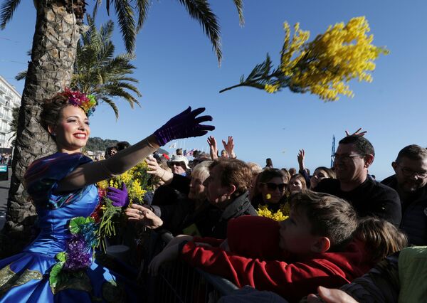 フラワーパレードの参加者たちに花を投げる女性　（フランス・ニース） - Sputnik 日本
