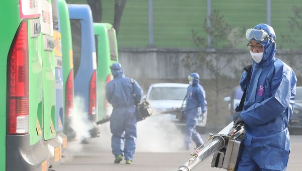 Работники службы дезинфекции распыляют дезинфицирующее средство в рамках профилактических мер против распространения коронавируса на автобусном терминале в Сеуле - Sputnik 日本