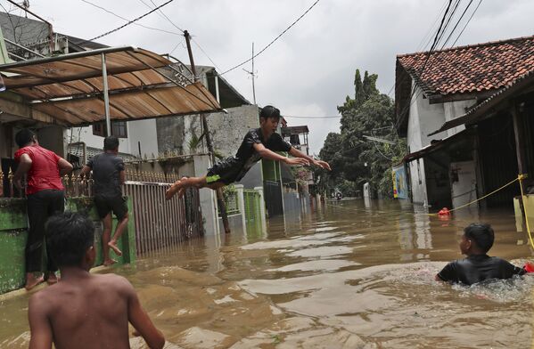 洪水に見舞われた街を楽しむ少年たち（インドネシア・ジャカルタ） - Sputnik 日本