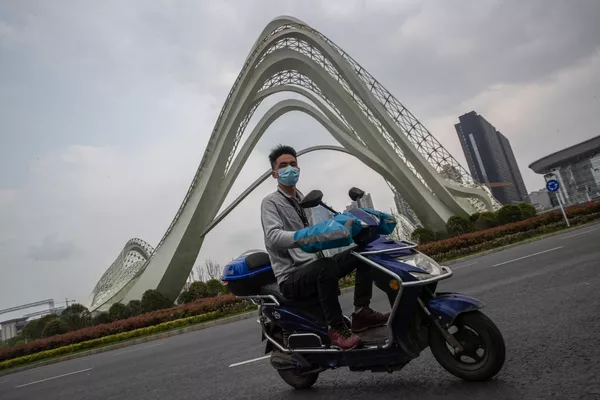 スクーターで街を走る武漢市民