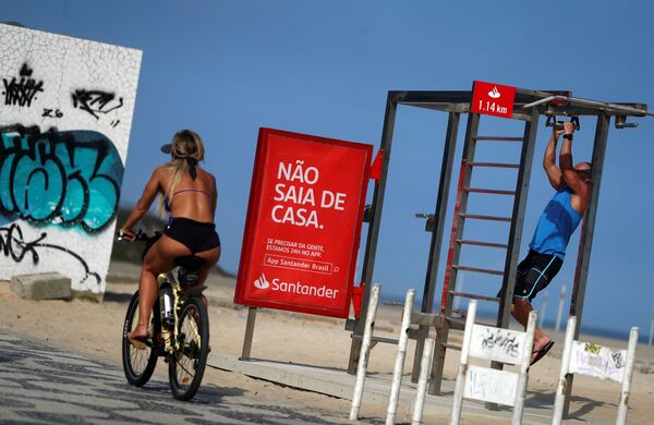 「家から出ないでください」と書かれた看板の前を通り過ぎる女性（ブラジル・リオデジャネイロ） - Sputnik 日本