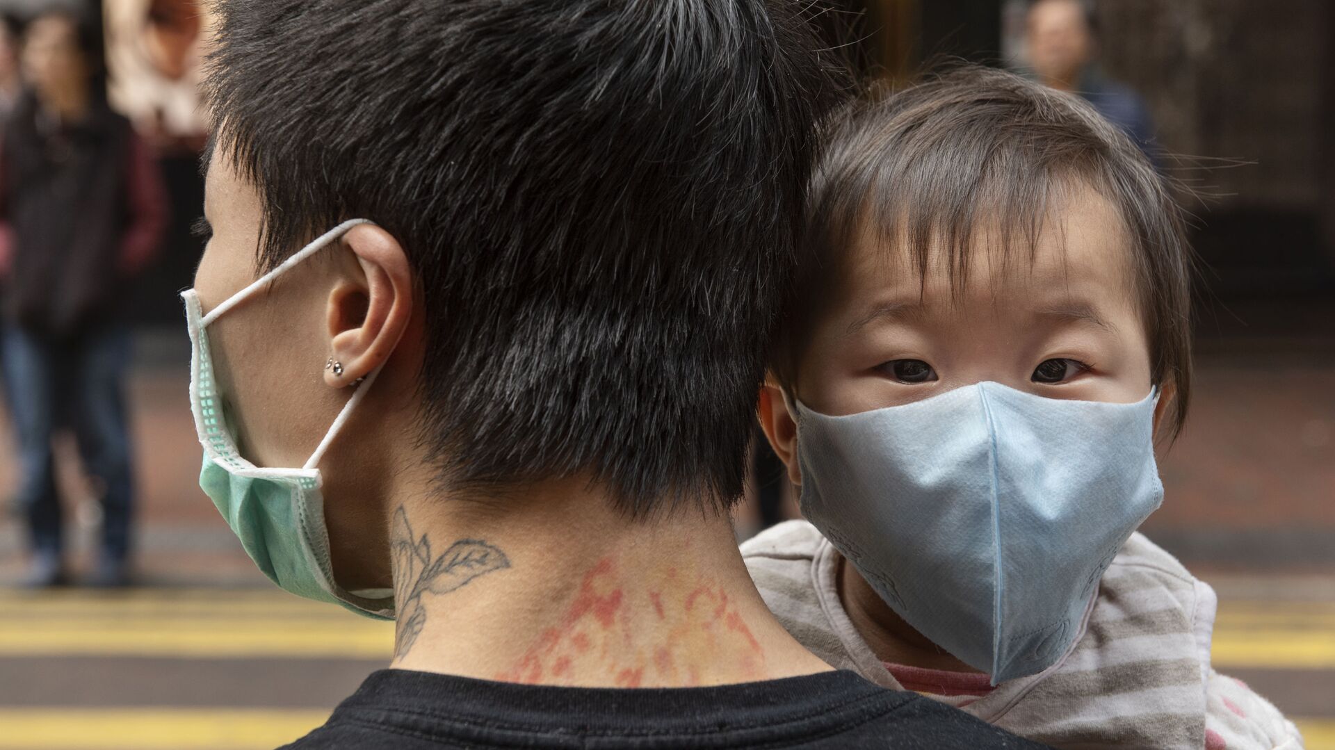 Ребенок в защитной маске на руках отца на одной из улиц в Гонконге - Sputnik 日本, 1920, 08.02.2022