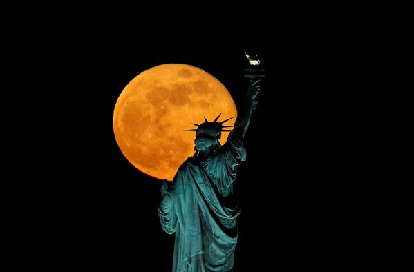 米ニューヨーク・ニュージャージーで観測されたフラワームーンと自由の女神
（5月7日撮影） - Sputnik 日本
