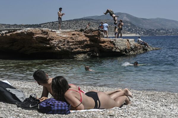 海辺で日光浴をする市民と海に飛び込む若者（ギリシャ、アテネ） - Sputnik 日本