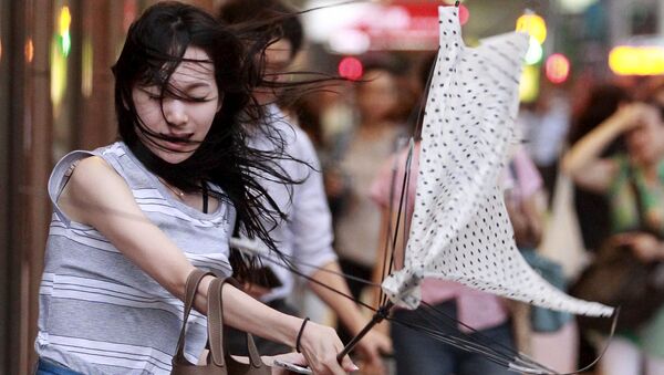 Девушка пытается открыть зонтик во время тайфуна «Соуделор» на острове Тайвань - Sputnik 日本