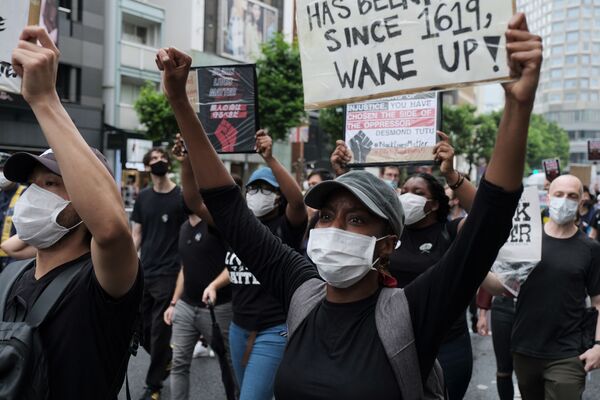 プラカードを掲げて通りを行進する「Black Lives Matter Tokyo」の参加者ら - Sputnik 日本