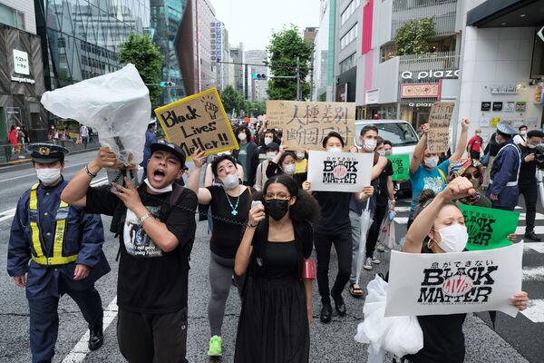 プラカードを掲げて通りを行進する「Black Lives Matter Tokyo」の参加者ら - Sputnik 日本