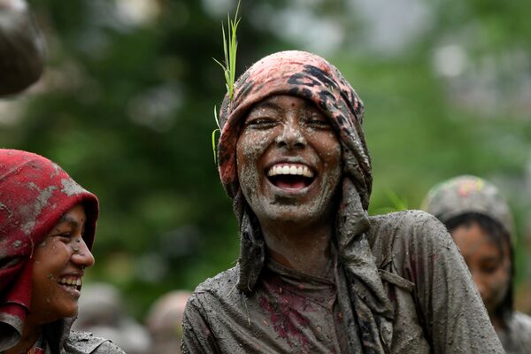田植えシーズンの始まりを告げる日「National Paddy Day」で、水田で笑顔を見せる女性（ネパール、カトマンズ） - Sputnik 日本