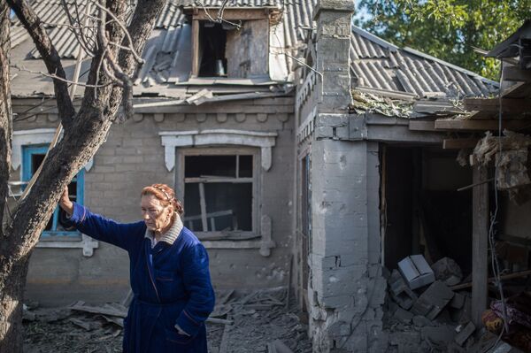 砲撃の結果、破壊された家の前に立つ女性。ウクライナ東部ドネツク州アレクサンドロフカ村。 - Sputnik 日本