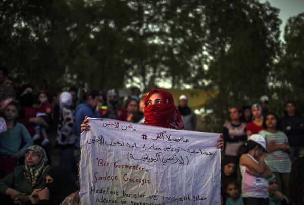 シリア女性、「我々は移民だ、我々は通過する。目的地はギリシャだ」とのプラカードを掲げる - Sputnik 日本